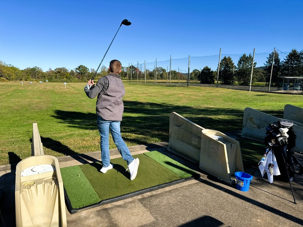Boy in mid-swing at the driving range